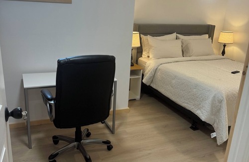 Ottawa Division House | Large bedroom with private bathroom and workspace.